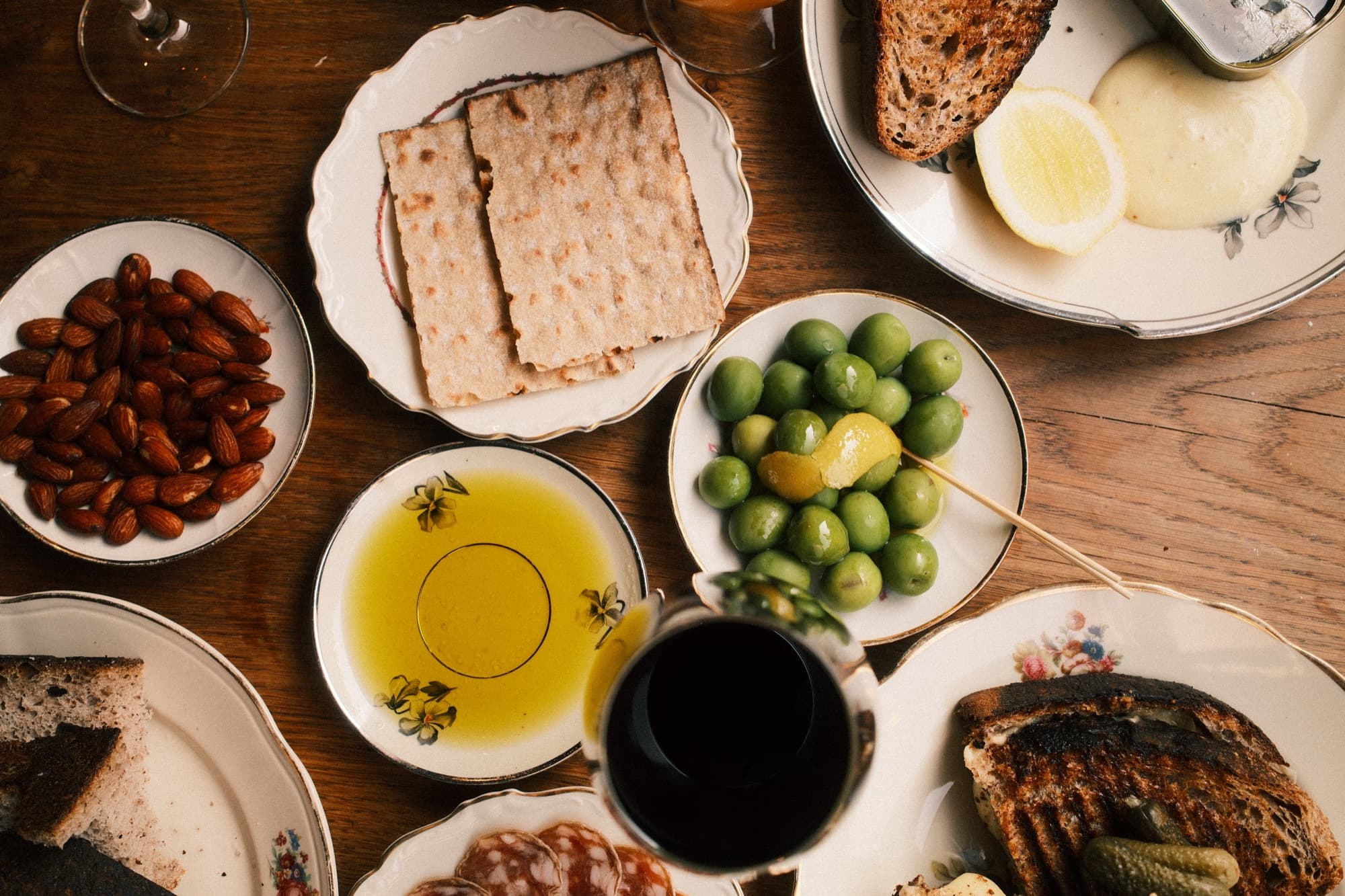 The table from above with charcuterie, cheese, olives, oil and toasted bread